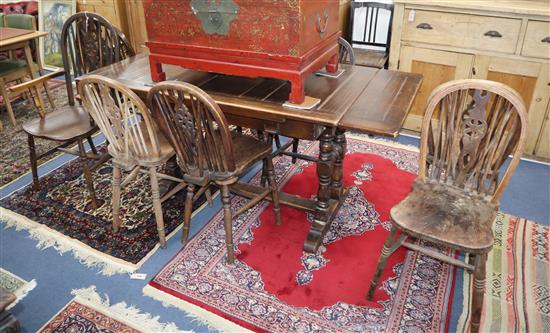 A beech extending dining table and nine wheel back chairs L.167cm fully extended